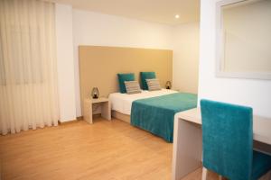 科尔武河畔米兰达Quinta do Viso Alojamento Local的一间卧室配有一张带绿色床单的床和一扇窗户。