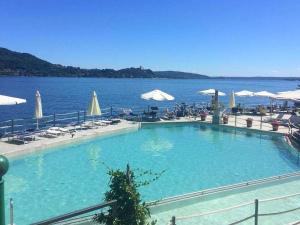 梅纳Brand new and elegant residence on Lake Maggiore的大型游泳池毗邻一大片水体