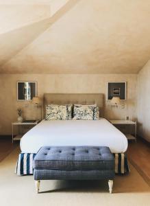 阿泽陶金塔德酒店的一间卧室配有一张大床和蓝色的搁脚凳