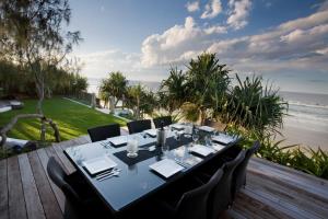 拜伦湾香巴拉@拜伦酒店的海滩景甲板上的餐桌