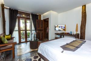 暹粒爪哇木制住宅别墅的一间卧室配有一张大床和电视