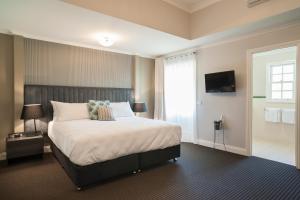 沃伯顿雅拉河奥斯卡酒店的一间卧室设有一张大床和一个窗户。
