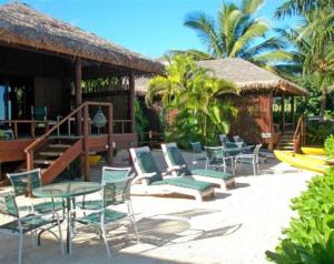 拉罗汤加拉罗汤加岛海滩简易别墅酒店的一个带桌椅的庭院和一个凉亭