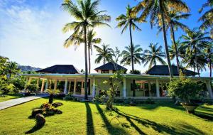 龙目岛库塔吉瓦那度假村的前面有棕榈树的房子