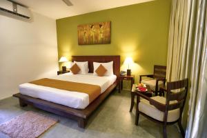 丹不拉Tropical Life Resort and Spa的一间卧室配有一张大床和一把椅子