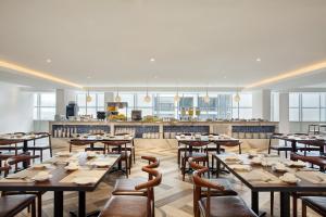 吉隆坡Days Hotel & Suites by Wyndham Fraser Business Park KL的一间带木桌椅的餐厅和一间厨房