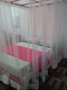 贝鲁沃勒伊莎贝拉酒店的一间卧室配有白色窗帘的床