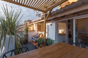 尼斯Ze Perfect Place - Vieux Nice - Exceptionnel Appartement - Calme et Terrasse avec vues的植物阳台的木桌