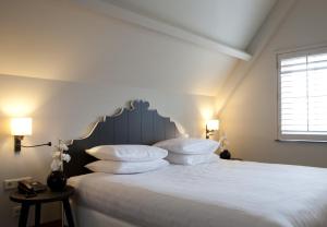 赫伊曾弗莱彻酒店 - 诺蒂什夸提尔餐厅的一间卧室配有带白色床单和枕头的床。