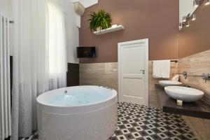莱切Donna Teresa Guest House的带浴缸、卫生间和盥洗盆的浴室