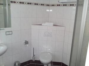 梅森瓷艺旅馆的白色的浴室设有卫生间和水槽。