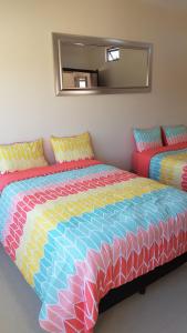 科利马Suites Lagunas的一间卧室配有一张大床和色彩缤纷的被子