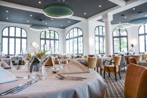布里德莱班Golf Hôtel的用餐室设有桌椅和窗户。