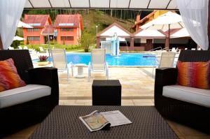 佩尼多Hotel Girassol的一个带两把椅子的庭院和一个游泳池