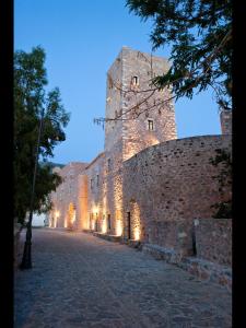 皮尔戈斯迪鲁Arapakis Historic Castle的一座大型城堡在晚上点燃