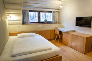 兹林考利巴瑟恩梅德韦贾酒店的一间卧室配有一张床、一张书桌和一台电视