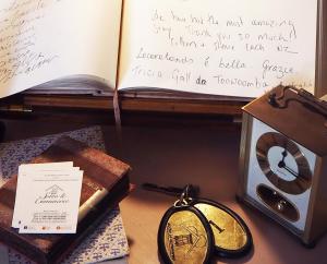 洛科罗通多Albergo Diffuso Sotto le Cummerse的一张桌子,上面有书,一个钟和一个钥匙链