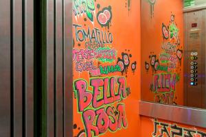 阿利坎特Tomate Rooms的上面涂有涂鸦的橙色墙