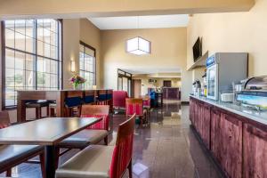 麦库姆Comfort Inn & Suites的一间带桌椅的餐厅和一间酒吧