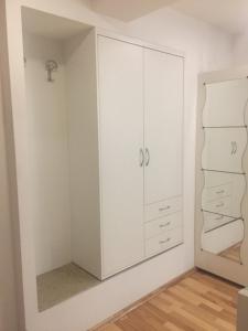 卢布尔雅那Apartment Red Square的卧室配有白色橱柜和镜子