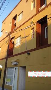 福尔摩沙WINTER Departamentos Temporarios的黄色的建筑,旁边标有标志