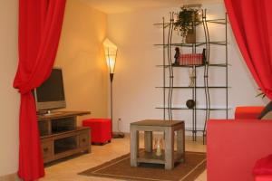 芒通Les Citronniers d'Azur的客厅配有红色窗帘和电视
