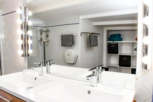 圣艾格夫Escale Au Soleil Hôtel et Appart的浴室设有白色水槽和镜子
