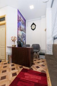 苏博蒂察Hostel Put Svile的一间设有书桌和墙上的时钟的房间