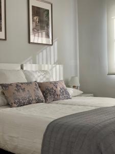 马拉加Diamond Apartments Puerto De Malaga的一间卧室配有带白色床单和枕头的床。