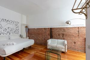 马德里马图特11号公寓的卧室配有白色的床和砖墙
