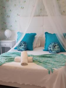 米尔芳提斯城Casa da Alagoinha的一张带蓝色枕头和天蓬的白色床