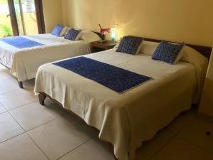 Barra de PotosiUn Escondite Mágico的客房内的两张床和蓝色枕头