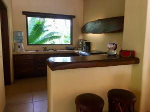 Barra de PotosiUn Escondite Mágico的厨房配有带2张凳子的柜台和窗户。