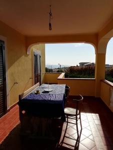 圣尼科拉阿尔切拉Aria Di mare的客房设有桌椅和大窗户。