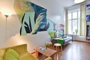 柏林柏林城艺术旅舍的客厅配有沙发和墙上的绘画
