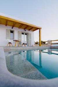 考弗尼西亚Aeris suites的一座房子旁带两把椅子的游泳池