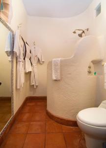 帕茨库卡罗谢洛波登酒店的浴室配有卫生间和挂在墙上的毛巾。