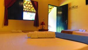 瓦尔任博尼塔Praia da Crioula的一间卧室设有两张床和两个窗户。