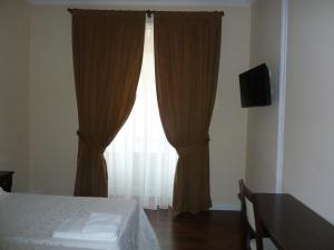 马德里梅耶旅馆的一间卧室配有床和带窗帘的窗户