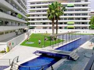 萨洛Apartamentos Riviera Niza 05的一座大型建筑,在一座建筑前设有一个游泳池