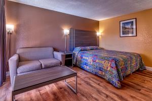 诺加利斯Siesta Motel的一间卧室配有一张床、一把椅子和一张桌子