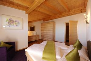 奥贝朴菲斯韦博酒店的一间卧室设有一张床和木制天花板