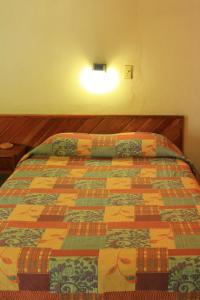 阿卡普尔科Hotel Avenida的一间卧室配有一张带五颜六色被子的床