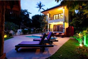 西塔努3 Bedroom Seafront Villa Island View SDV233-By Samui Dream Villas的一组躺椅在房子前