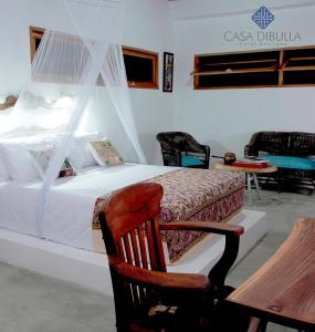 DibullaCasa Dibulla Hotel Boutique的一间卧室配有一张床、一把椅子和一架钢琴