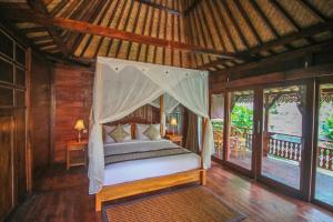 乌布Ari Cottages Ubud的度假村内一间卧室配有一张天蓬床