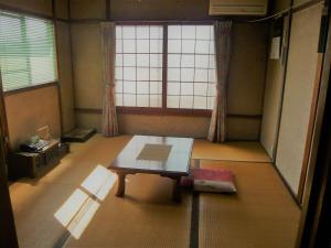 仓敷Kofuji Ryokan的窗户前设有桌子的房间