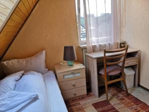 Gadernheim泽尔巴查胡福宾馆的一间卧室配有一张床、一张桌子和一把椅子