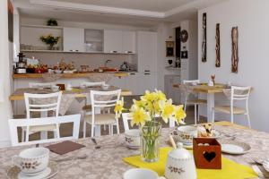 巴塞尔加·迪·皮纳Bike Bed&Breakfast Mille Pini的厨房以及带黄色花卉桌子的用餐室