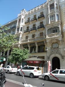 马德里梅耶旅馆的一座大型建筑,前面有汽车停放